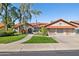 Charming single-story home with a red tile roof, arched entry, lush green lawn, and mature landscaping at 17030 N 57Th St, Scottsdale, AZ 85254