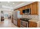 Well-equipped kitchen with stainless steel appliances, wooden cabinets, tile countertops and eat-in dining area at 17030 N 57Th St, Scottsdale, AZ 85254