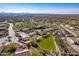 Expansive aerial view of a community with mature landscaping, pools, and mountain views in the distance at 17303 N 98Th Pl, Scottsdale, AZ 85255
