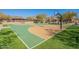 A well-maintained basketball court with new paint, surrounded by artificial turf and a playground in the distance at 17303 N 98Th Pl, Scottsdale, AZ 85255