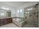 Elegant bathroom featuring a soaking tub, walk-in shower with glass door, and granite countertop vanity at 17303 N 98Th Pl, Scottsdale, AZ 85255