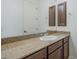 Bathroom vanity featuring granite countertop, dark wood cabinets, and large mirror at 17303 N 98Th Pl, Scottsdale, AZ 85255