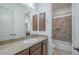 Well-lit bathroom with granite countertop vanity and a view into the tiled shower/tub area at 17303 N 98Th Pl, Scottsdale, AZ 85255