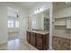 Bathroom with granite countertops, sink, large mirror, and open access to bedroom at 17303 N 98Th Pl, Scottsdale, AZ 85255