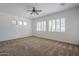 Spacious bedroom features plush carpet, ceiling fan, and plantation shutters for natural light at 17303 N 98Th Pl, Scottsdale, AZ 85255