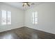 Clean, sunlit bedroom with wood floors, a ceiling fan, and white plantation shutters on the windows at 17303 N 98Th Pl, Scottsdale, AZ 85255
