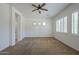 Bedroom with neutral carpet, ceiling fan, and large window with plantation shutters at 17303 N 98Th Pl, Scottsdale, AZ 85255