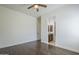 Bright, unfurnished bedroom with hardwood floors, ceiling fan, and doorway to en-suite bathroom at 17303 N 98Th Pl, Scottsdale, AZ 85255