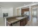 Kitchen island with sink and wooden cabinets, stainless steel dishwasher, complemented by views of the living room and fireplace at 17303 N 98Th Pl, Scottsdale, AZ 85255