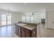 Kitchen island with granite countertops, a sink, and wooden cabinetry, connecting to the open living space at 17303 N 98Th Pl, Scottsdale, AZ 85255