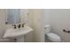 Stylish powder room featuring pedestal sink, dark fixtures, and a modern toilet at 17303 N 98Th Pl, Scottsdale, AZ 85255