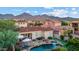 Stunning aerial view of a home with a pool, spa, putting green, and patio, all set against a backdrop of majestic mountains at 18500 N 95Th St, Scottsdale, AZ 85255
