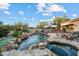 Wonderful backyard, showing the pool with rock features, and a fire pit on a sunny day at 18500 N 95Th St, Scottsdale, AZ 85255