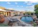 Inviting backyard featuring a pool, rock waterfall, and a shaded lounge area for ultimate relaxation and entertaining at 18500 N 95Th St, Scottsdale, AZ 85255