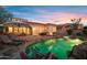 Inviting backyard with a sparkling pool, lounge chairs, and cozy fire pit under a beautiful sunset sky at 18500 N 95Th St, Scottsdale, AZ 85255