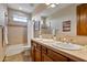 Bathroom featuring double sinks, wood cabinets, tile backsplash, and a shower with tub at 18500 N 95Th St, Scottsdale, AZ 85255