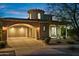 Exterior elevation shows a two-story home with a barrel tile roof and an arched portico at dusk at 18500 N 95Th St, Scottsdale, AZ 85255