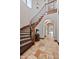 Grand foyer featuring a curved staircase with decorative tile risers and arched doorways, highlighting elegant architectural details at 18500 N 95Th St, Scottsdale, AZ 85255