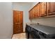 Functional laundry room features wooden cabinets, tile floors, and high-end washer and dryer units at 18500 N 95Th St, Scottsdale, AZ 85255