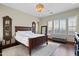 Comfortable main bedroom featuring a dark wood bed, stylish mirrors, and a large window at 18500 N 95Th St, Scottsdale, AZ 85255