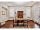 Well-lit home office with hardwood floors, plantation shutters, and stylish rustic furniture, creating a comfortable workspace at 18500 N 95Th St, Scottsdale, AZ 85255