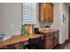 Home office with a dark wood desk, chair, cabinets, and natural light from a window at 18500 N 95Th St, Scottsdale, AZ 85255