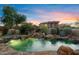 Resort-style pool with a rock waterfall and lush landscaping, creating a serene and luxurious backyard oasis at 18500 N 95Th St, Scottsdale, AZ 85255