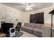 This bedroom features quirky splatter paint, a ceiling fan and a comfortable gray futon sofa at 21181 N 80Th Ln, Peoria, AZ 85382