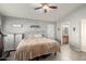 Serene primary bedroom featuring neutral tones, a ceiling fan, and a glimpse into the attached bathroom at 21181 N 80Th Ln, Peoria, AZ 85382