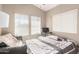 Bright bedroom featuring sunny windows, a gray quilted bedspread and a dark leather chair at 21181 N 80Th Ln, Peoria, AZ 85382