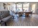 Bright dining area with large window, wood-look flooring, and rustic wood table with bench at 21181 N 80Th Ln, Peoria, AZ 85382