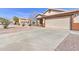 Single-story home with a wide driveway leading to a two-car garage and desert-style landscaping at 21181 N 80Th Ln, Peoria, AZ 85382