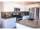 Modern kitchen features granite countertops, stainless steel appliances, and white cabinets at 21181 N 80Th Ln, Peoria, AZ 85382