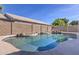 An inviting backyard pool with a rock waterfall feature surrounded by a brick wall at 21181 N 80Th Ln, Peoria, AZ 85382