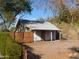 Small home with a wooden fence, surrounded by trees and greenery on a sunny day at 2206 N 11Th St, Phoenix, AZ 85006
