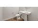 Cozy powder room features modern fixtures, a pedestal sink, and wood look floors at 22660 E Pegasus Pkwy, Queen Creek, AZ 85142