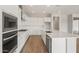 A modern kitchen featuring bright white cabinets, quartz countertops, and stainless steel appliances at 22660 E Pegasus Pkwy, Queen Creek, AZ 85142