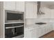 A modern kitchen featuring stainless steel microwave, oven, white cabinets and quartz countertops at 22660 E Pegasus Pkwy, Queen Creek, AZ 85142