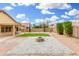 This landscaped backyard features a built-in fire pit, covered patio, and neatly trimmed hedges at 2300 E Austin Dr, Gilbert, AZ 85296