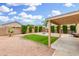This backyard has a large covered patio area, gravel, trimmed hedges and lawn, and an outdoor fire pit at 2300 E Austin Dr, Gilbert, AZ 85296