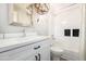 This bright bathroom has a stylish light fixture above a vanity, a toilet, and a tiled shower-tub at 2300 E Austin Dr, Gilbert, AZ 85296