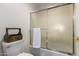 Bathroom featuring a bathtub with sliding glass doors and a wooden caddy on the toilet at 24916 N 80Th Ln, Peoria, AZ 85383