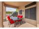 Inviting covered patio with a dining table, comfortable seating, and exterior lighting at 24916 N 80Th Ln, Peoria, AZ 85383