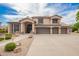 Charming two-story home with a three-car garage, covered entry, tile roof, and desert landscaping at 24916 N 80Th Ln, Peoria, AZ 85383