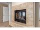 A cozy fireplace with decorative tile and modern glass enclosure offers warmth and style at 24916 N 80Th Ln, Peoria, AZ 85383