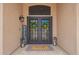 Stylish double front doors with decorative wreaths, a 'WELCOME' mat, and elegant exterior lighting fixtures at 24916 N 80Th Ln, Peoria, AZ 85383