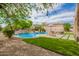 Inviting pool area with lush landscaping, patio, and clear blue skies at 24916 N 80Th Ln, Peoria, AZ 85383