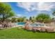 Stunning pool with rocks, lush green grass and a seating area at 24916 N 80Th Ln, Peoria, AZ 85383