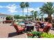 Lush backyard featuring a fire pit with chairs, sofas, swimming pool, and mature palm trees at 2527 E Beechnut Ct, Chandler, AZ 85249