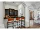Elegant bar area with dark cabinetry, black countertops, seating for three, and striking architectural details at 2527 E Beechnut Ct, Chandler, AZ 85249